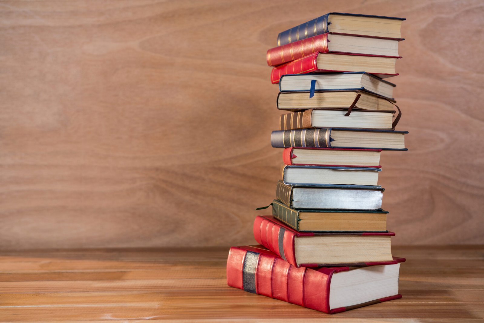 Stack of various books on a wooden table
